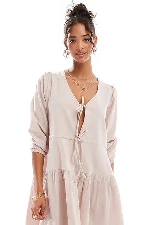 Esmée – Langärmliges, gestuftes, kurzes Strandkleid aus Leinenmix in Hellbeige mit geschnürter Vorderseite