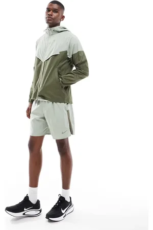 Nike – Windrunner – Jacke in Hellgrün und Khaki im Bahnen-Design