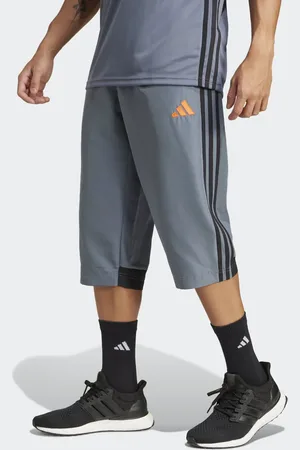 adidas – Tiro 25 Essentials – Dreiviertellange, gewebte Hose in Team Onix, und Super Orange
