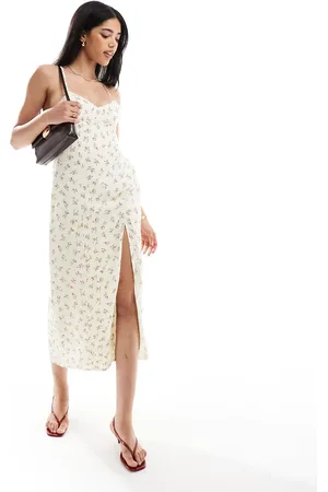 Bershka – Midaxi-Trägerkleid in Buttergelb mit überkreuzter Rückseite und Blumenmuster