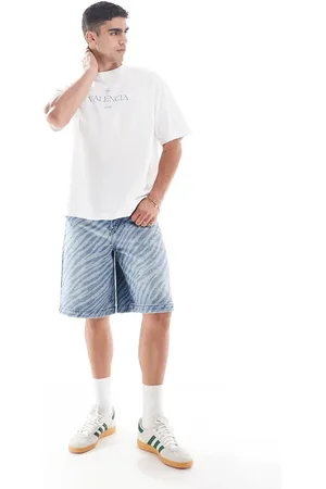 ASOS – Lange Denim-Jorts in mittelblauer Waschung mit Zebra-Laserprint und Farbstich