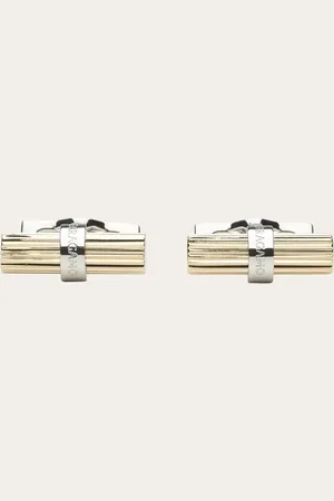Salvatore Ferragamo Essentielles, grafisches Flair: die neuen Manschettenknöpfe bestehen aus einem gerändelten zylindrischen Element mit hellgoldenem Finish und einem Stäbchen mit eingravierter Signatur