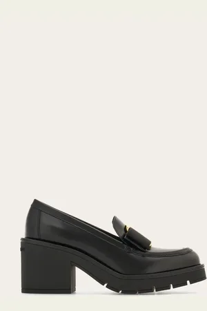 Salvatore Ferragamo Großstädtische Evolution des Loafers mit Absatz aus gebürstetem Kalbsleder und mit Vara Bow als Verzierung auf dem Spann: die goldene Maxi-Plakette und das Ripsband sorgen für eine romantische Note auf den ausdrucksstarken Linien des Oberma