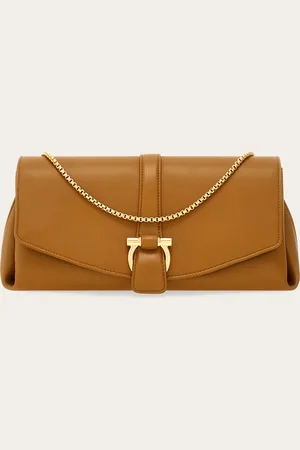 Salvatore Ferragamo Schlicht, rein in der Form und extrem feminin: Die neue Umhängetasche enthüllt ein besonderes Konzept der Eleganz, das in den klaren Geometrien, dem geschmeidigem Kalbsleder mit halbglänzendem Finish und dem goldenen Schein der Metallbeschl