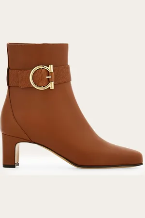 Salvatore Ferragamo Perfekt zu Hosen, aber auch besonders vielseitig zu Kleidern: die Knöchelstiefelette zeigt sich hier mit Obermaterial aus weichem, glattem Kalbsleder, verziert mit einem Lederband mit farblich abgestimmtem Echsen-Print und goldenem Gancini-