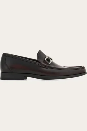 Salvatore Ferragamo Eleganter Loafer mit zulaufender Linie, verziert mit einer lackierten Spange und Gancini-Details aus glänzendem Metall