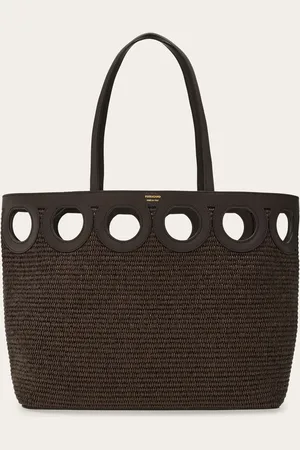 Salvatore Ferragamo Geräumig und vielseitig im mediterranen Stil: Die neue Tragetasche ist von den klassischen Coffa-Taschen aus geflochtenem Stroh inspiriert und mit elegant perforiertem Leder verziert, dessen Form an das ikonische Gancini erinnert